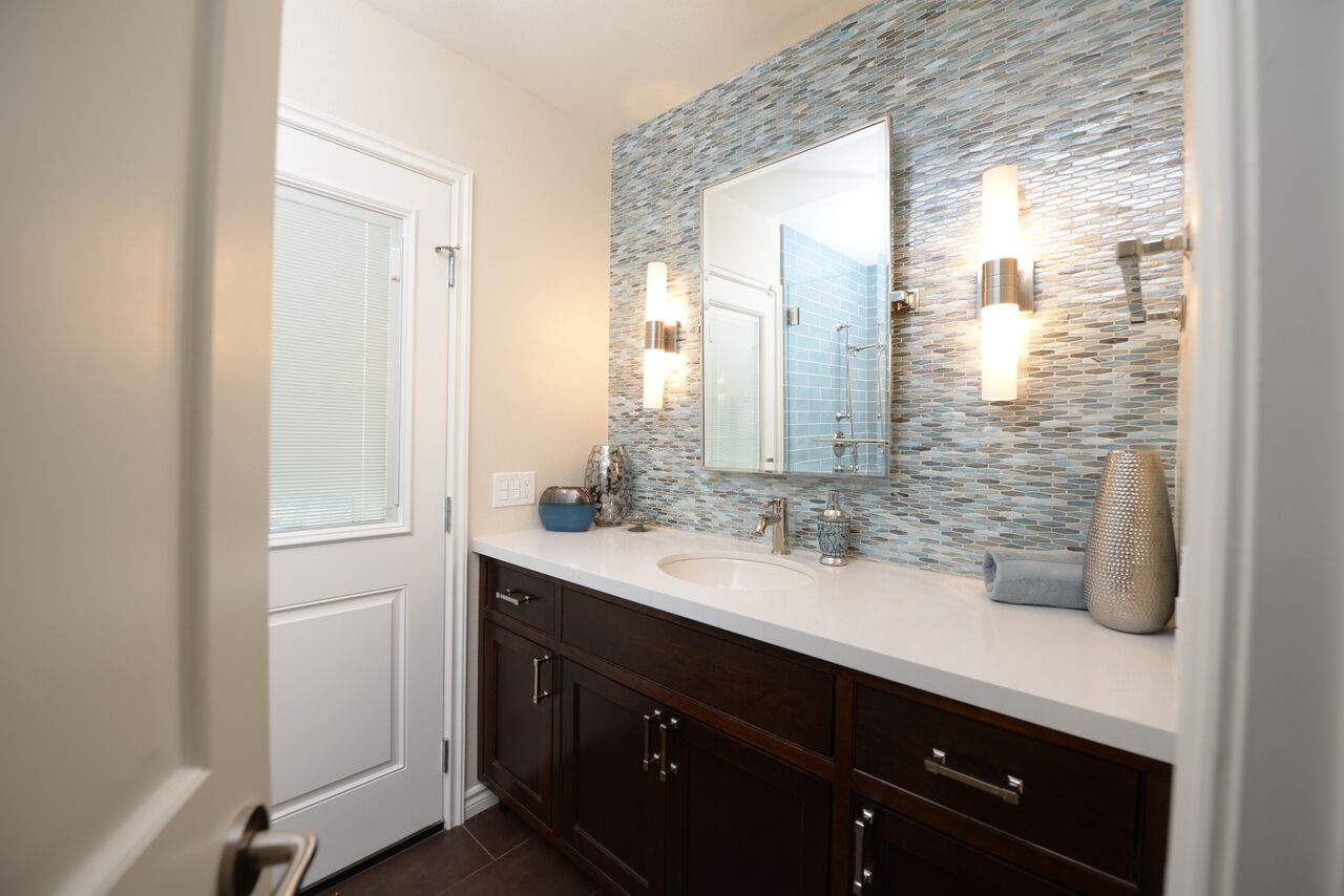 Interior design with custom vanity and wall of backsplash glass tile.