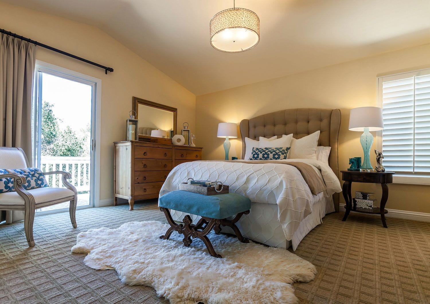 Patterned carpet and custom bedding with farmhouse dresser.