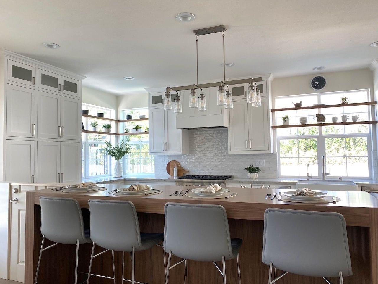 Kitchen design with shelves running across windows, handmade tile backsplash andj custom made bar.