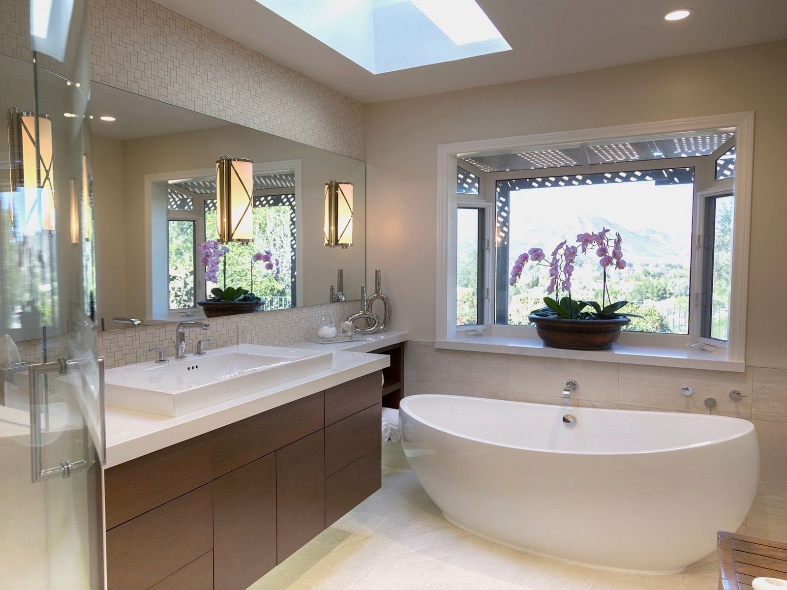 Beautiful bathroom with floating vanity and free standing tub. Accents and wall sconces.